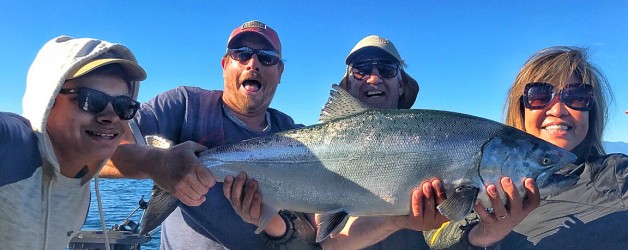 Holding up a monster size salmon on a fishing trip